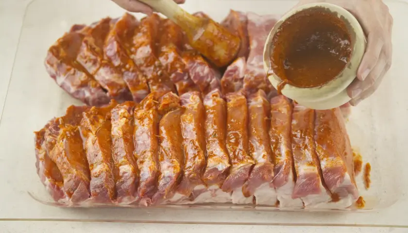 Costillas de lomo adobado listas para cocinar, cubiertas con una sabrosa marinada roja.
