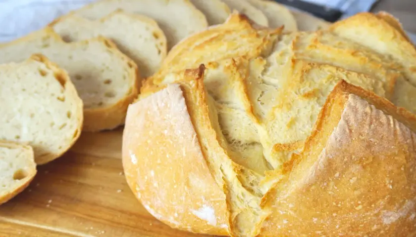 Pan casero recién horneado, dorado y crujiente, listo para disfrutar. Aprende como hacer pan en casa con esta deliciosa hogaza.