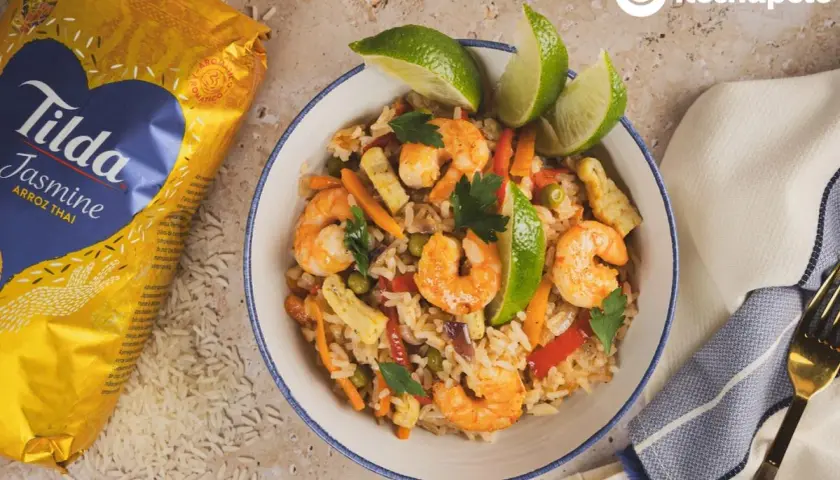 Delicioso arroz con langostinos, zanahoria, guisantes y pimiento rojo, decorado con lima y perejil. ¡Un plato para chuparse los dedos!