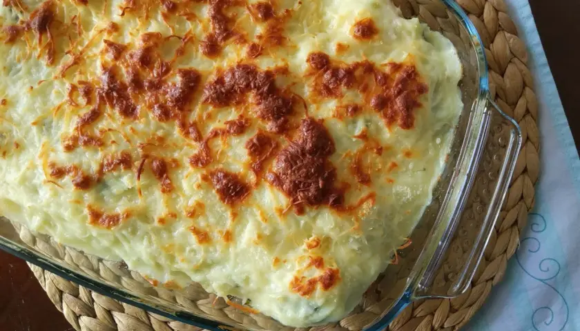 Parmentier de patata gratinado, con una capa dorada de queso fundido y burbujeante, listo para servir.
