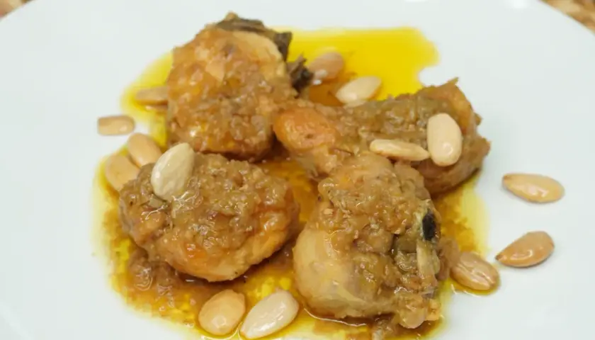 Sabroso pollo con almendras, bañado en una salsa dorada y adornado con almendras enteras.