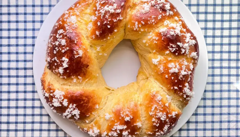 Rosca de Pascua dorada y brillante, espolvoreada con azúcar, lista para compartir en familia.