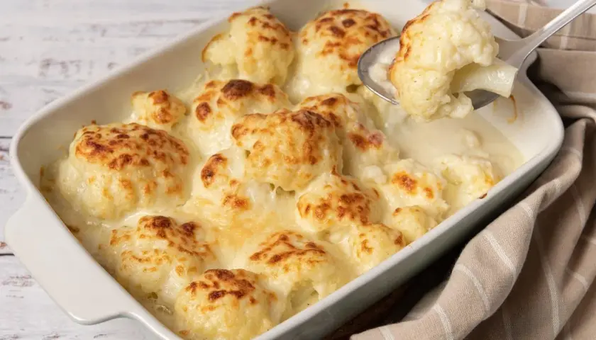 Coliflor gratinada con bechamel cremosa, lista para servir. Un plato reconfortante y delicioso.