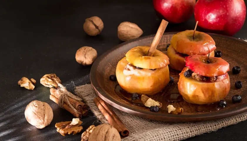 Deliciosas manzanas al horno con canela, nueces y arándanos, un postre casero perfecto.