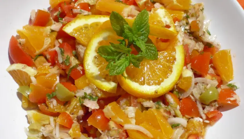 Ensalada de naranja fresca con tomates, aceitunas y menta. Una explosión de sabor cítrico y vibrante.