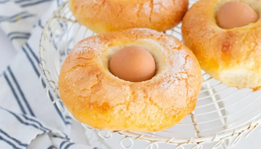 Monas de Pascua doradas y azucaradas, con un huevo cocido en el centro, listas para celebrar la primavera.