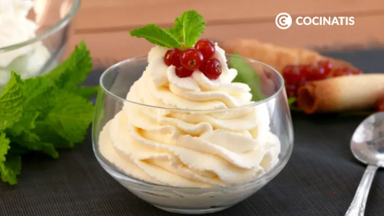 Deliciosa nata montada en copa, coronada con grosellas rojas y menta. Perfecta para cualquier postre.