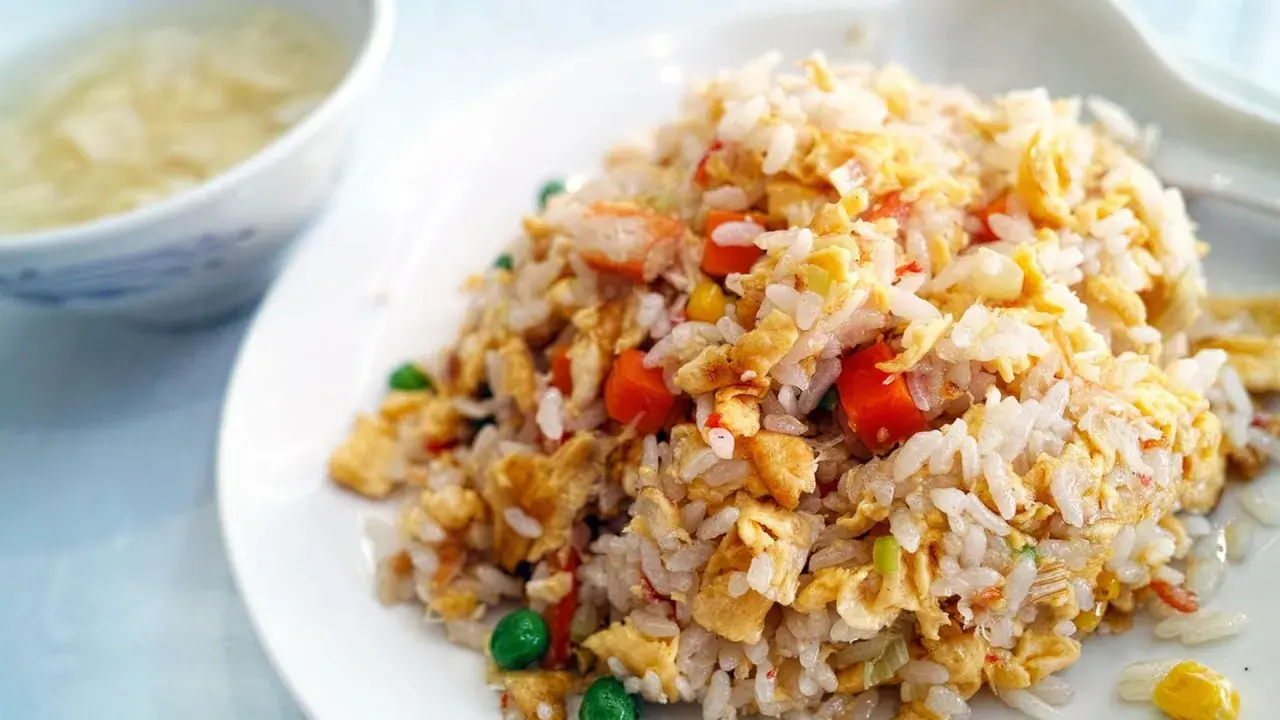 Arroz tres delicias con trozos de huevo, zanahoria y guisantes. Un plato delicioso y colorido.