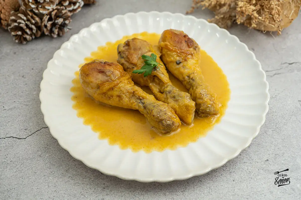 Tres jamoncitos de pollo en una cremosa salsa amarilla, decorados con perejil. ¡Un plato casero delicioso!