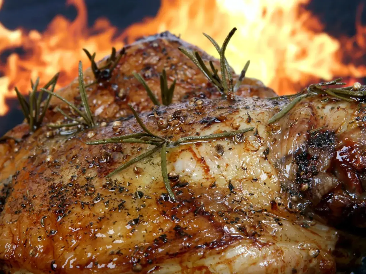 Pierna de cordero al horno, dorada y jugosa, con romero fresco y especias, lista para ser disfrutada.
