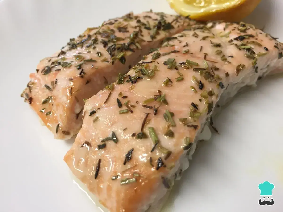 Dos jugosos filetes de salmón al horno, cubiertos con hierbas aromáticas y un toque de limón.