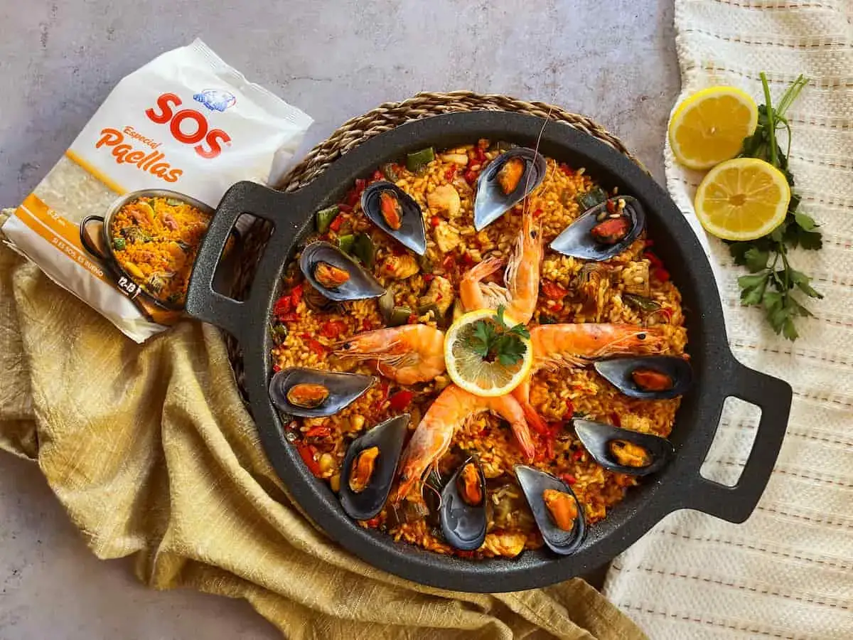 Paella mixta con gambas, mejillones y arroz dorado, lista para disfrutar.