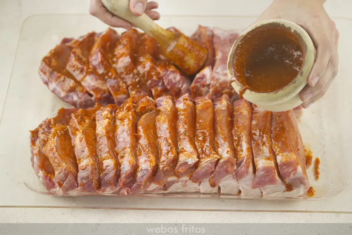 Costillas de lomo adobado listas para cocinar, cubiertas con una sabrosa marinada roja.