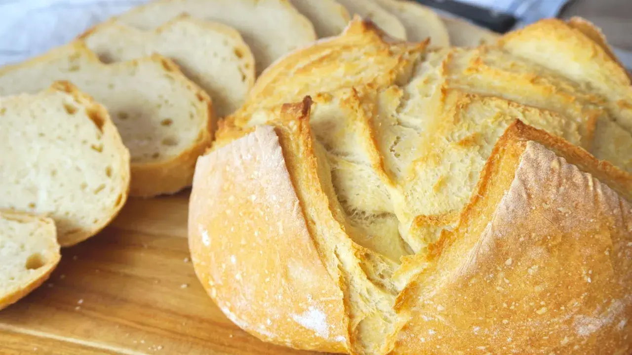 Pan casero recién horneado, dorado y crujiente, listo para disfrutar. Aprende como hacer pan en casa con esta deliciosa hogaza.