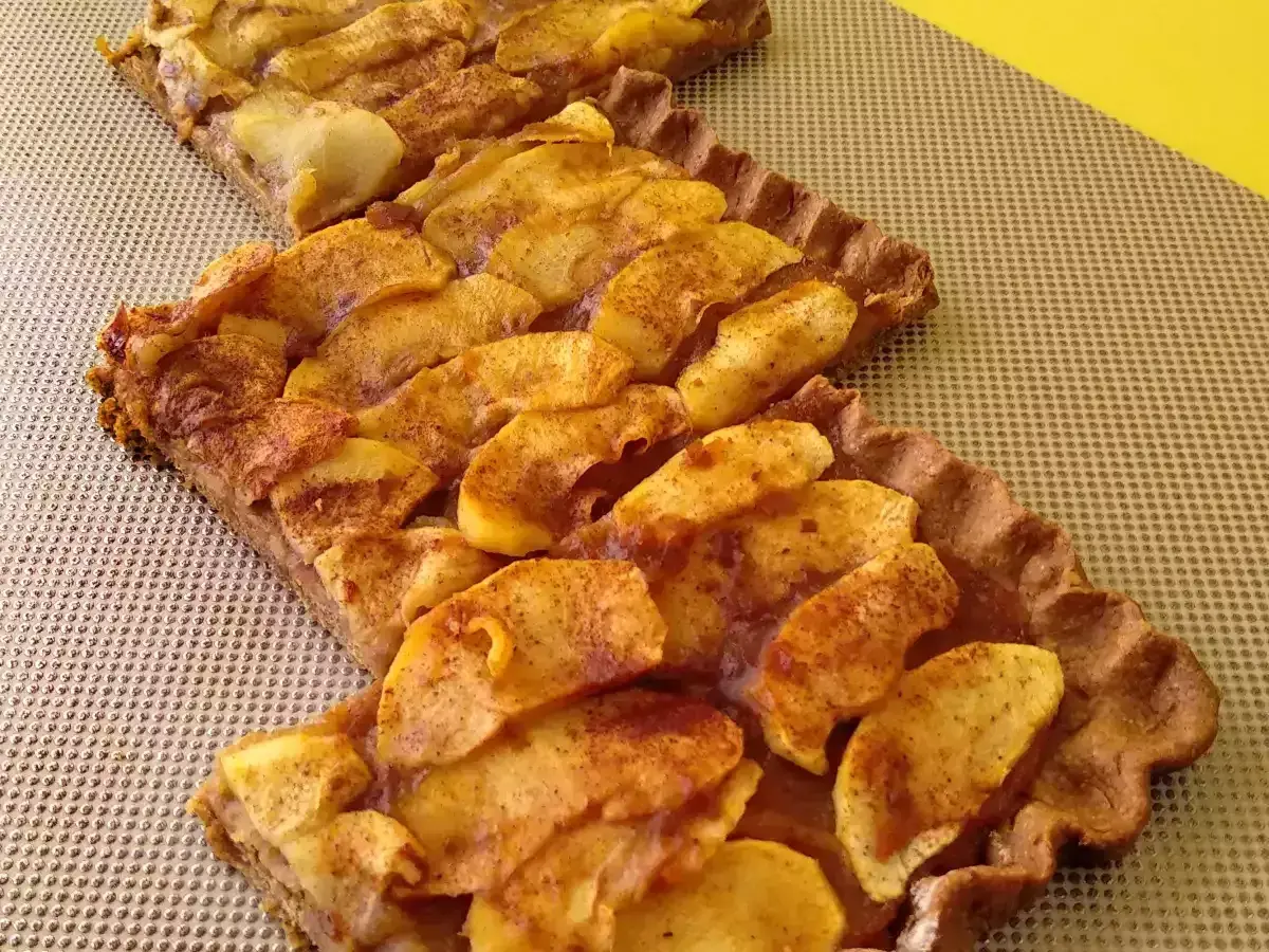 Dos porciones de tarta de manzana casera, con trozos de manzana dorados y espolvoreados con canela sobre una base crujiente.