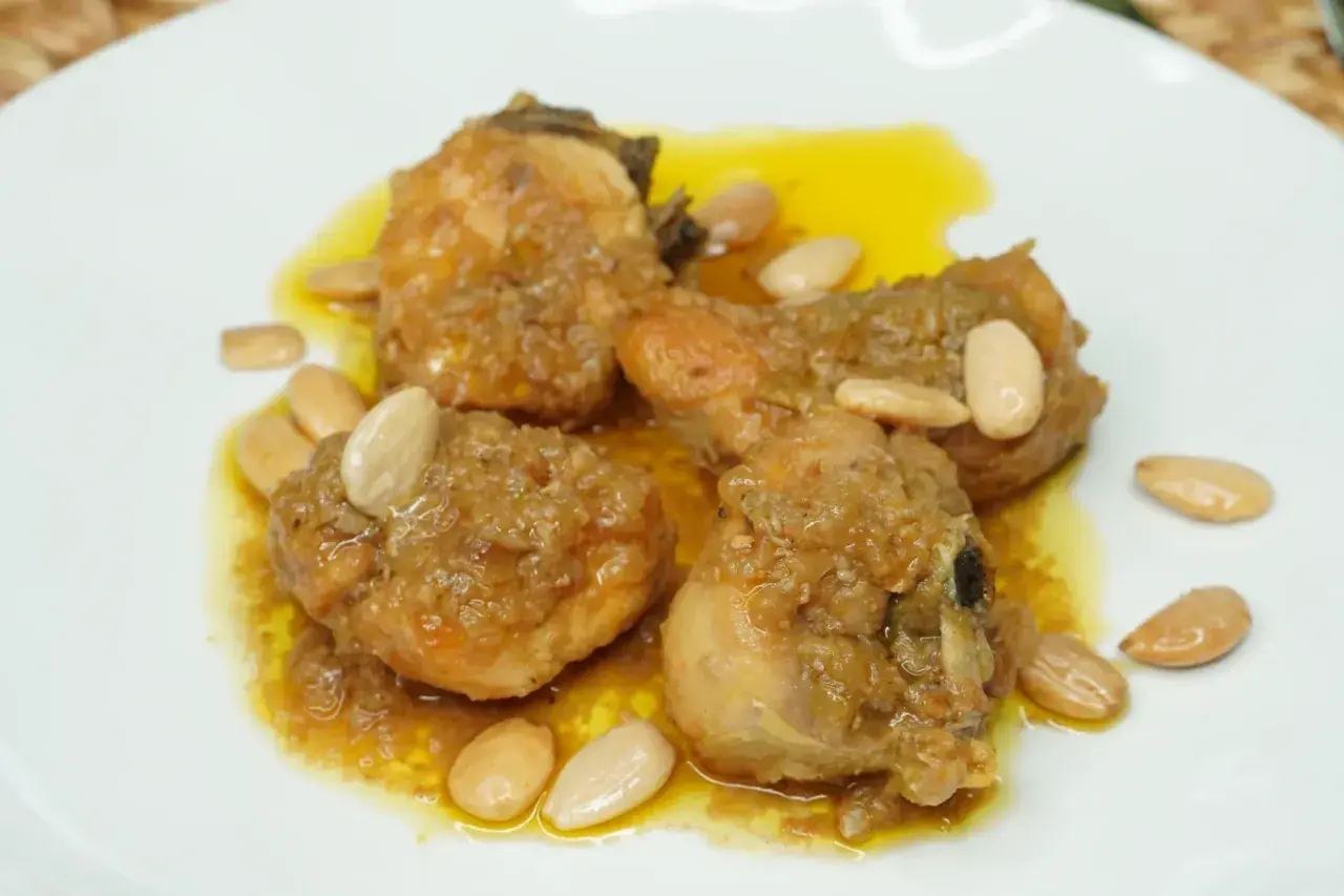 Sabroso pollo con almendras, bañado en una salsa dorada y adornado con almendras enteras.