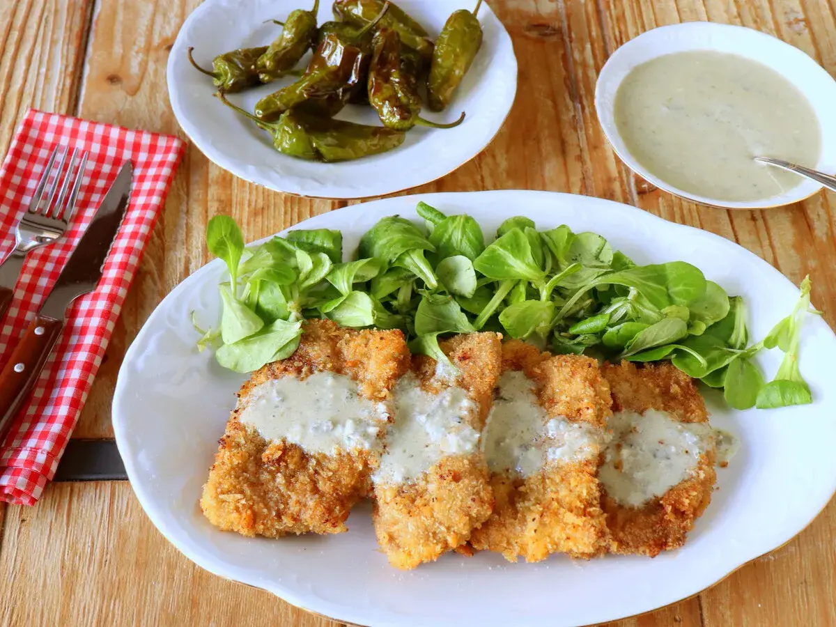Escalopines al cabrales crujientes, servidos con ensalada verde y pimientos de Padrón.