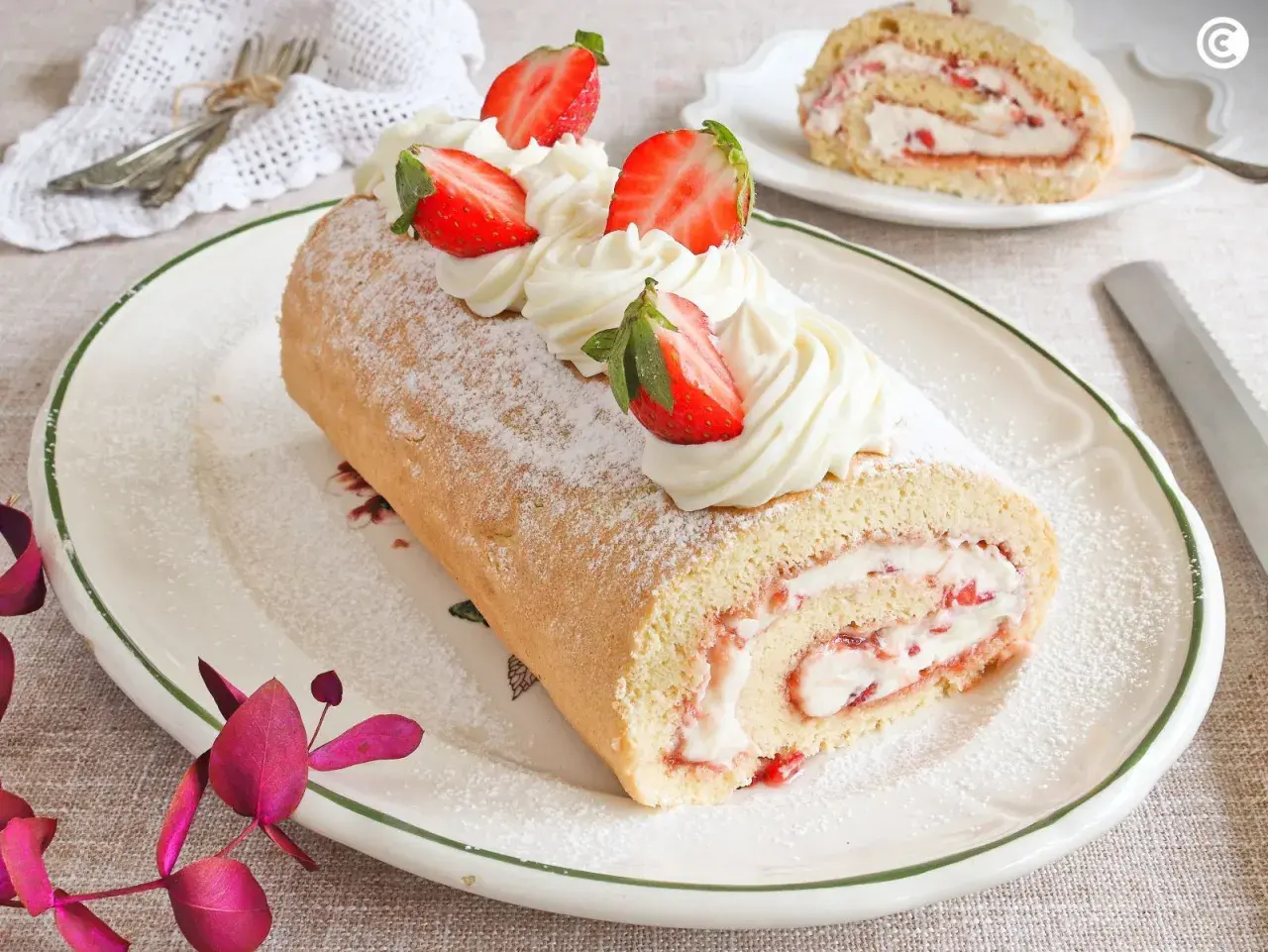 Un delicioso brazo de gitano con crema y fresas, espolvoreado con azúcar glas.
