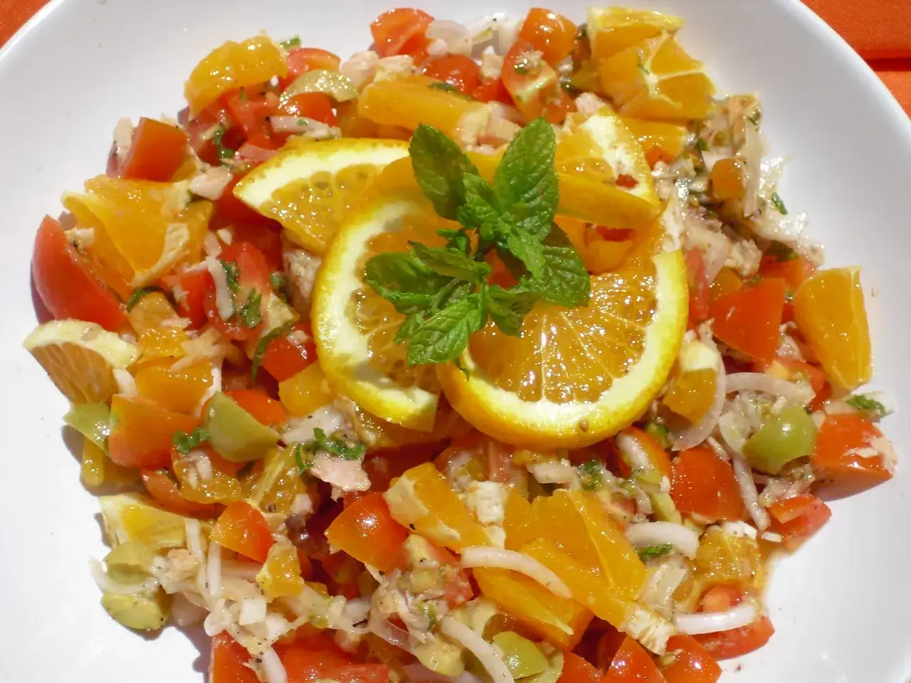 Ensalada de naranja fresca con tomates, aceitunas y menta. Una explosión de sabor cítrico y vibrante.