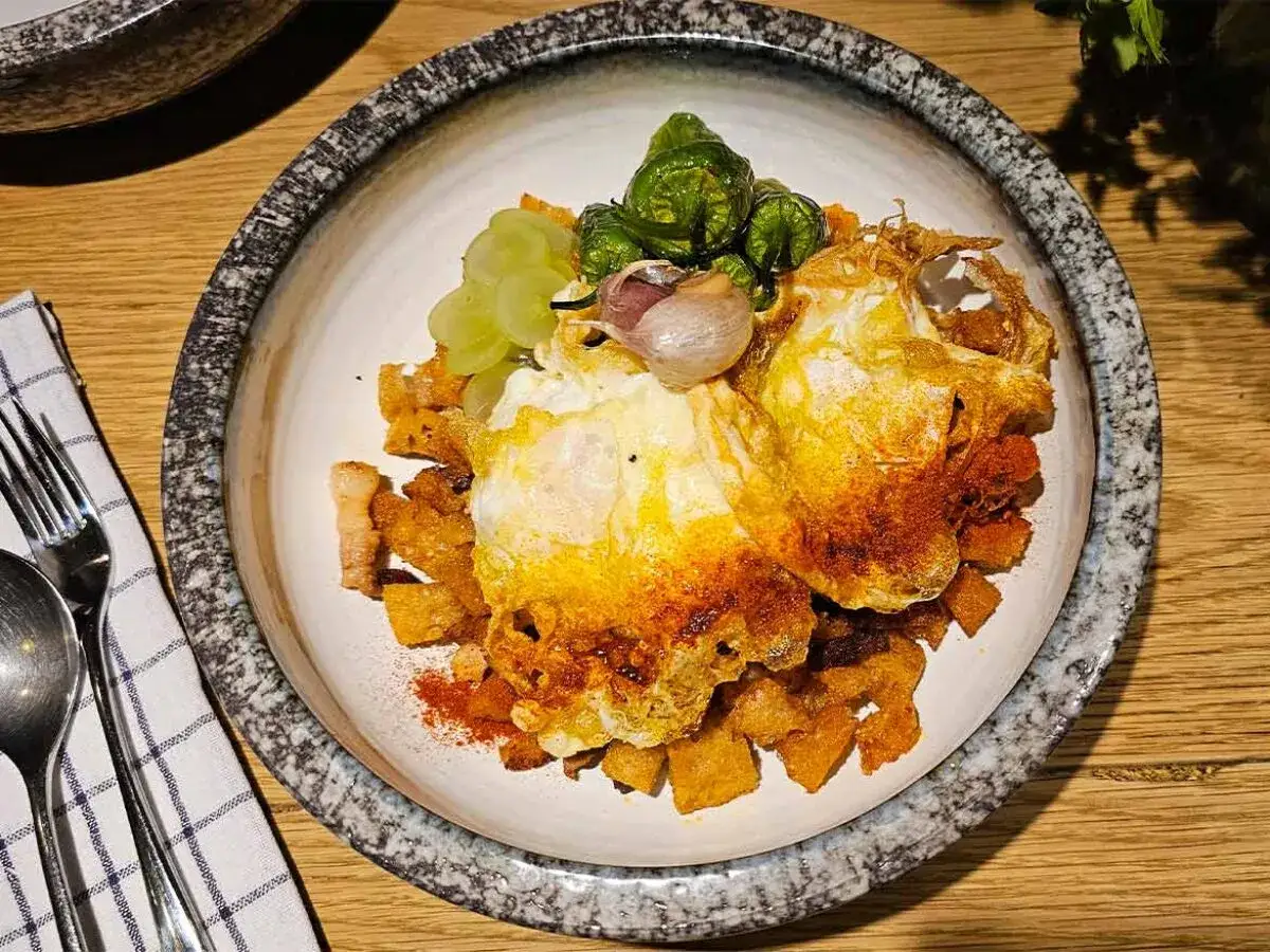 Deliciosas migas manchegas con huevos fritos, ajo y pimientos verdes. Un plato tradicional español.