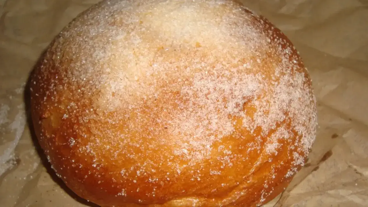 Un pan dulce espolvoreado con az&uacute;car, con un ligero toque dorado que recuerda al pan quemado.