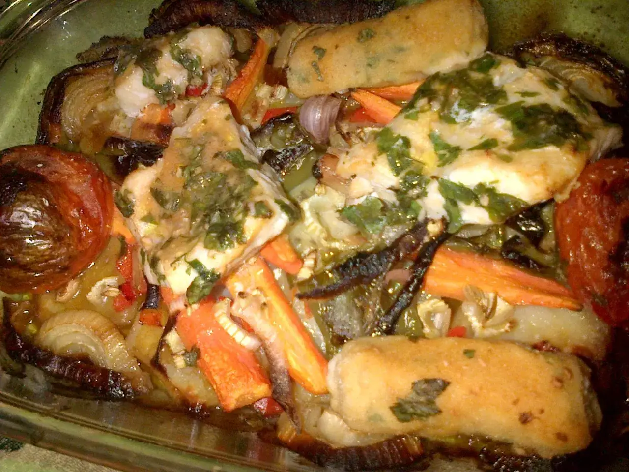 Delicioso pescado rosado al horno con verduras asadas, zanahorias y cebolla.