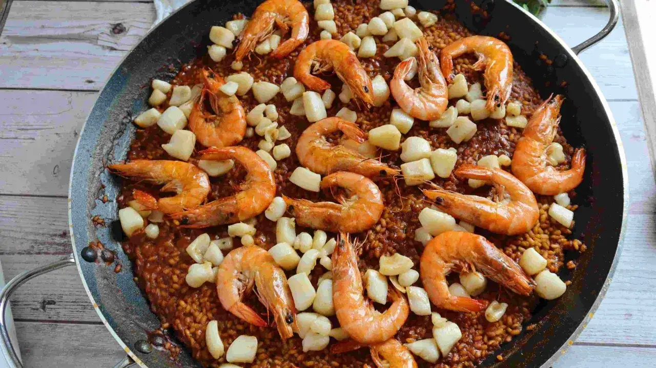 Arroz con sepia y gambas, un plato lleno de sabor y color, listo para disfrutar.