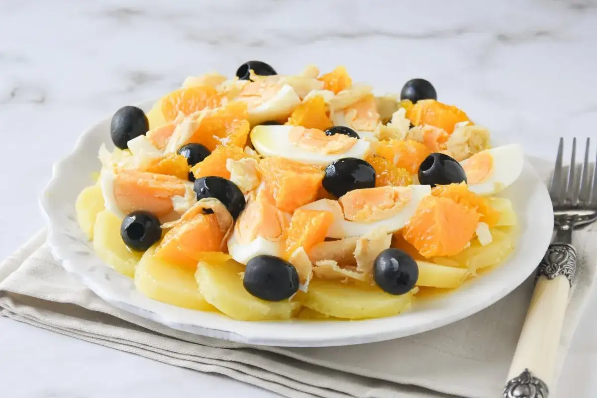 Deliciosa ensalada de naranja con patatas, huevo duro, bacalao desmigado y aceitunas negras.
