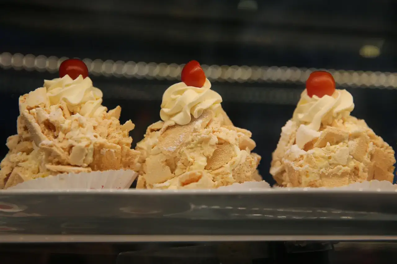 Tres postres de merengue con crema y cereza, un delicioso polvito uruguayo.