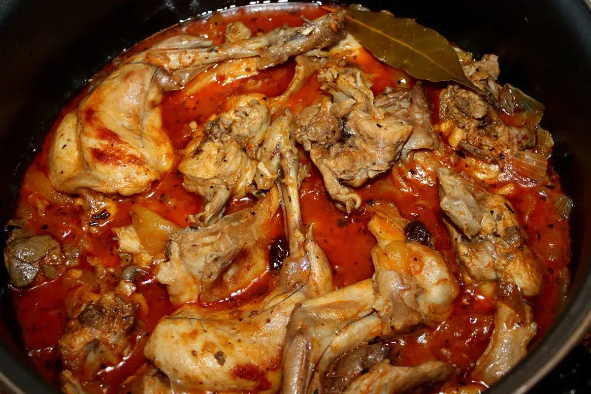 Un delicioso conejo en salsa, cocinado a fuego lento con especias y hierbas, listo para ser servido.