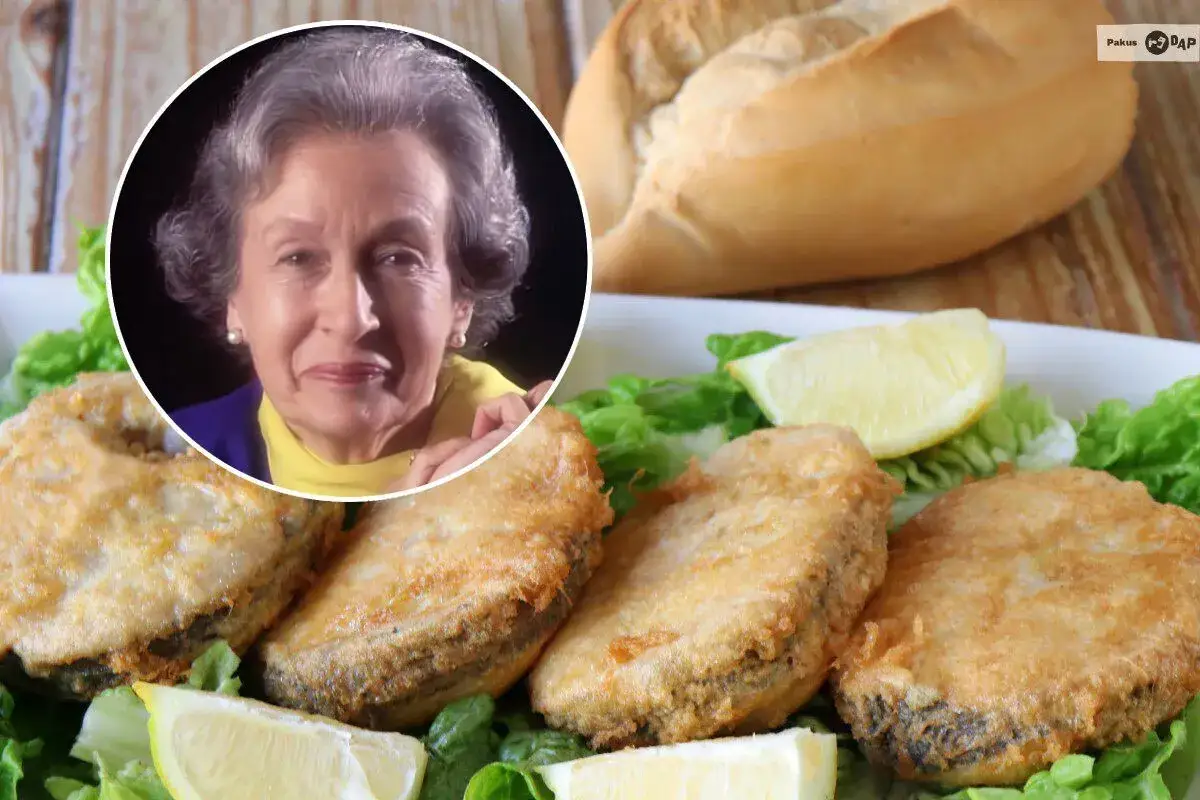 Mujer sonríe junto a plato de merluza a la romana, con lechuga y limón.