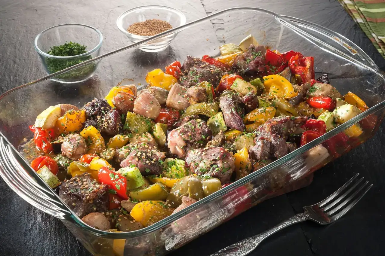 Sabroso redondo de ternera asado con pimientos de colores, calabac&iacute;n y especias, listo para servir.
