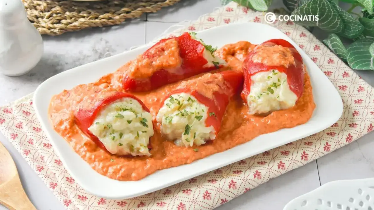 Pimientos rojos rellenos de bacalao desmigado y cubiertos con una cremosa salsa de pimientos.