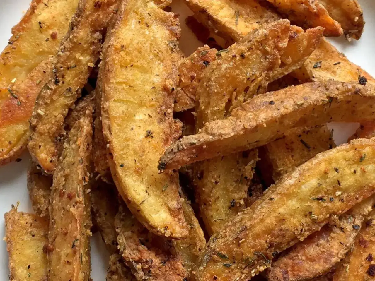 Patatas fritas al horno crujientes y doradas, sazonadas con hierbas y especias. ¡Un aperitivo delicioso y saludable!